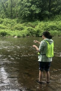 Lucas Forman taking a water sample from the Hoosic River.